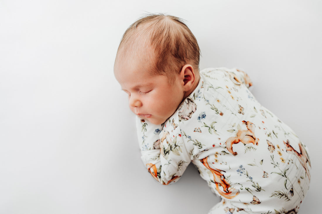 Sleeping newborn baby wearing a soft woodland-print bamboo sleeper, showcasing the gentle comfort and breathability ideal for sensitive skin.